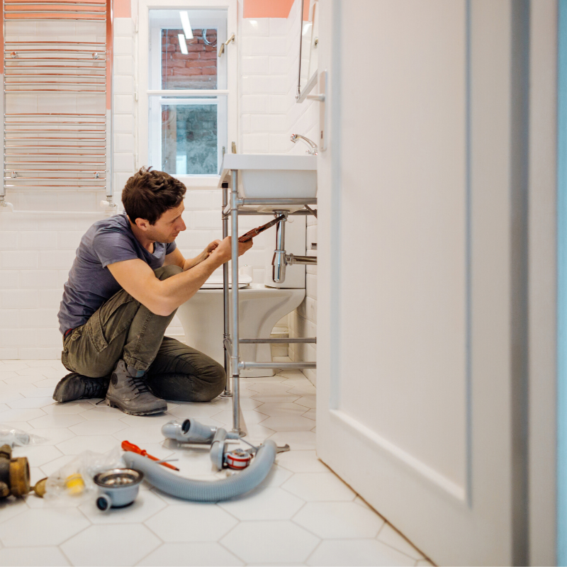 Plumber fixing a bathroom sink with tools